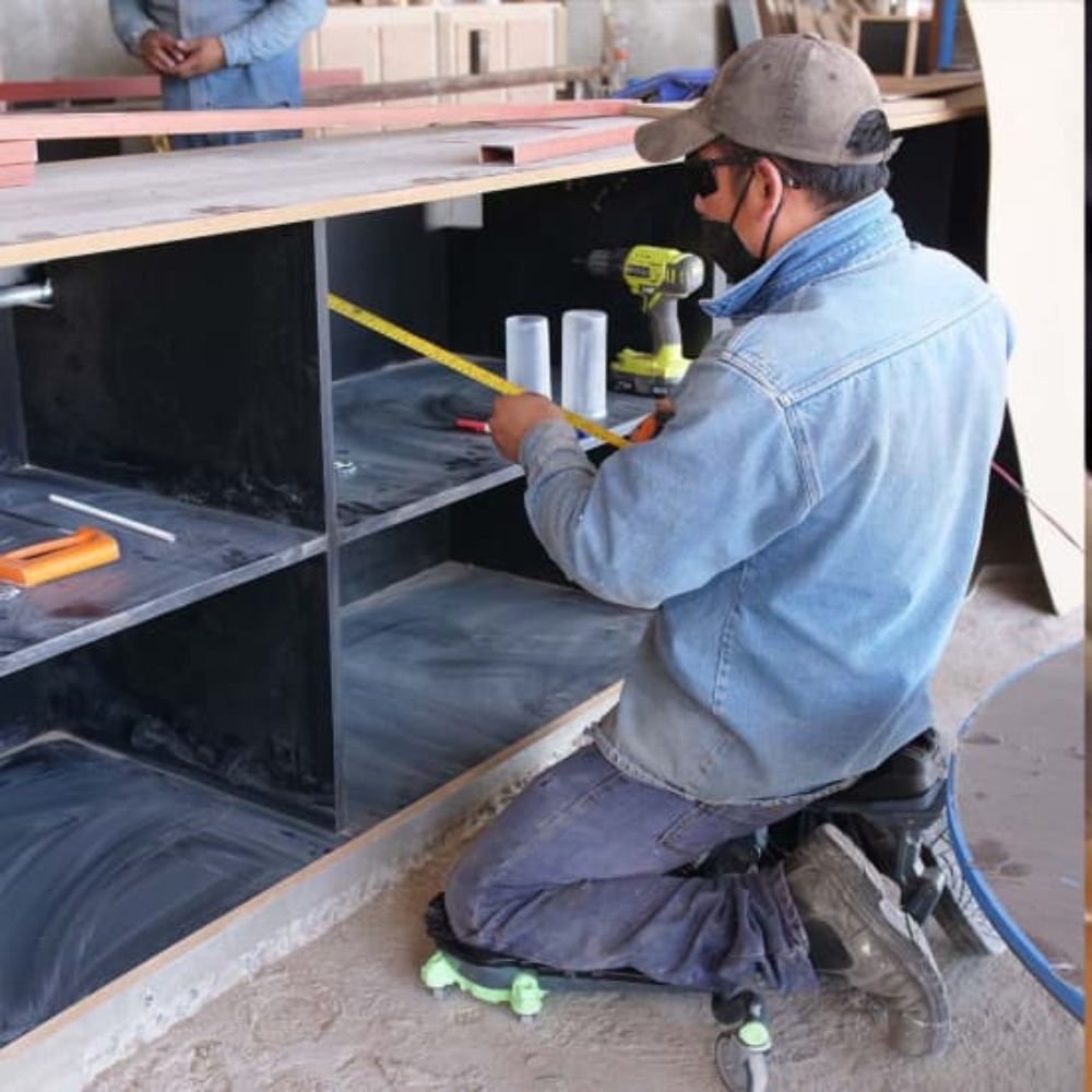 Man on the Kneel-It V3 measuring the depth of a cabinet for precise installation