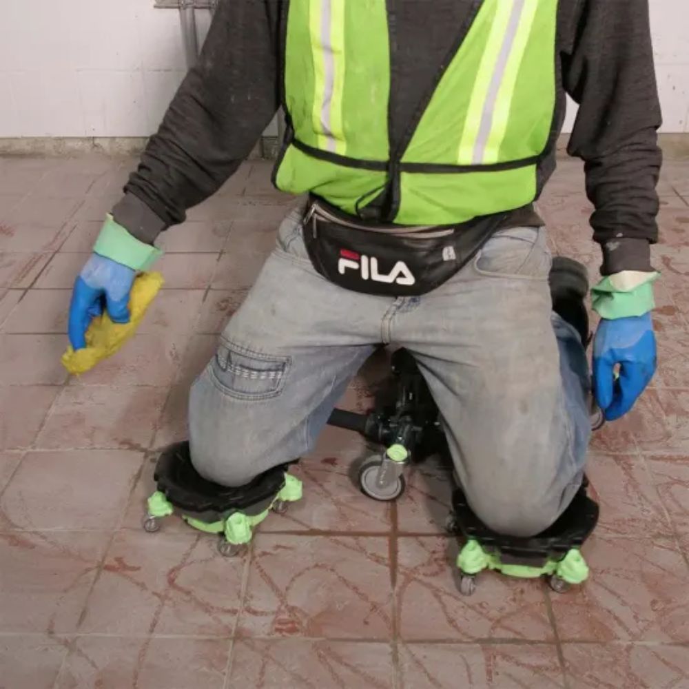 Front view of a man using Kneel-It V3 to comfortably clean grout from a tiled floor