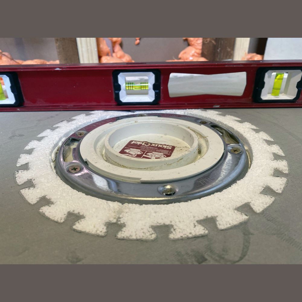 Self-leveling toilet flange seal for monolithic underlayment