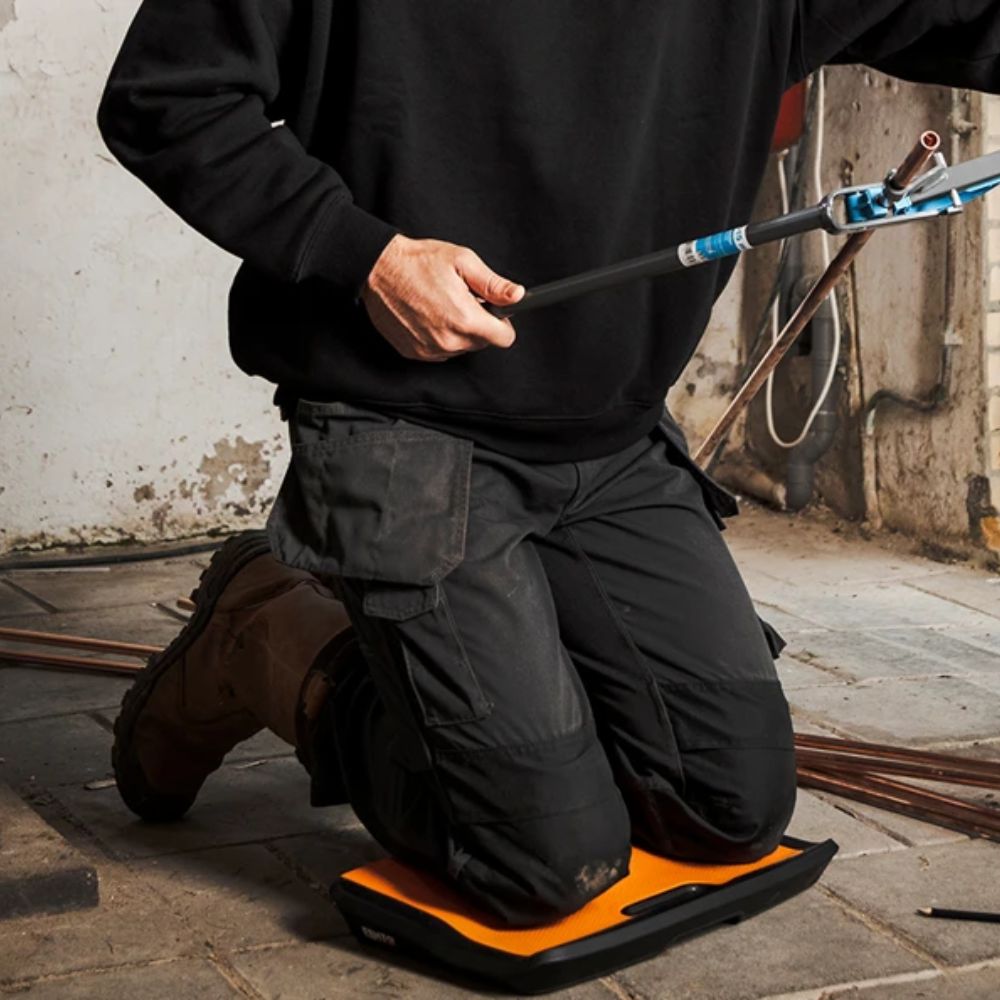 Contractor kneeling on FENTO BOARD M2 on concrete slab