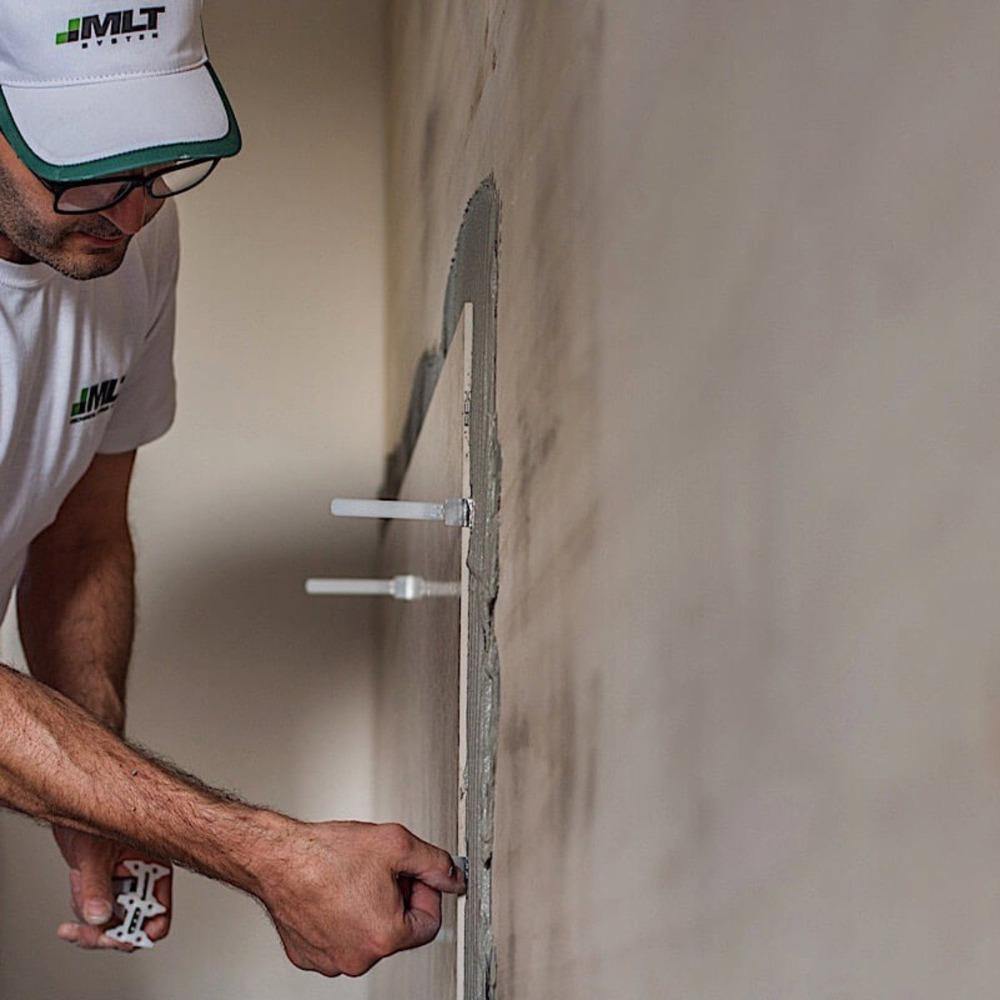 Installer positioning MLT baseplates during tile leveling application
